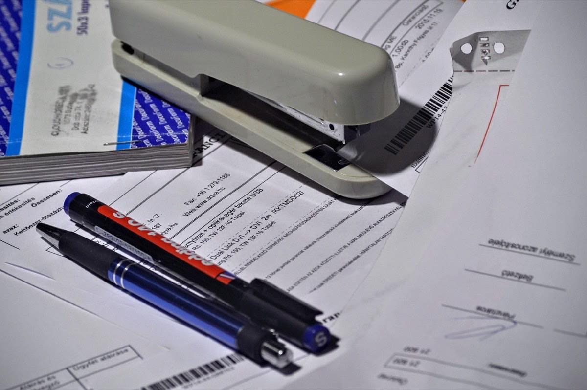 stapler, pen, paperwork, invoice
