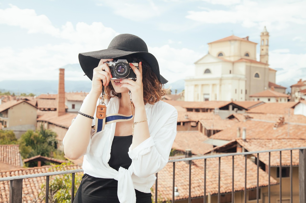 Fotógrafa disparando desde una terraza sobre los tejados de un pueblo