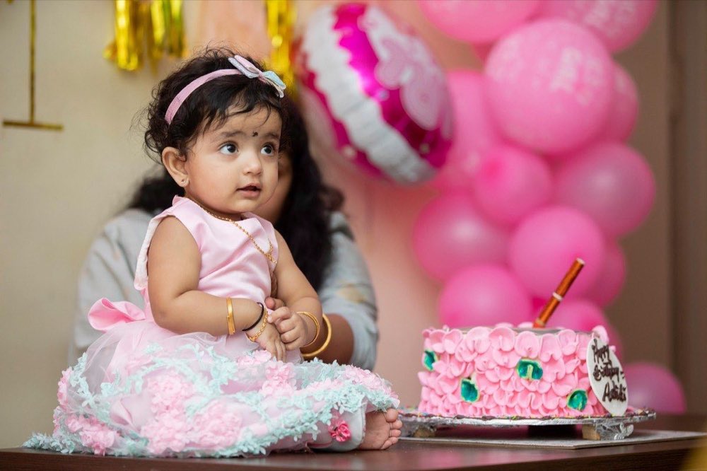 Bebé frente a un pastel de cumpleaños decorado